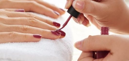 Classic Manicure Square Image of Side view of manicurist applying nail polish