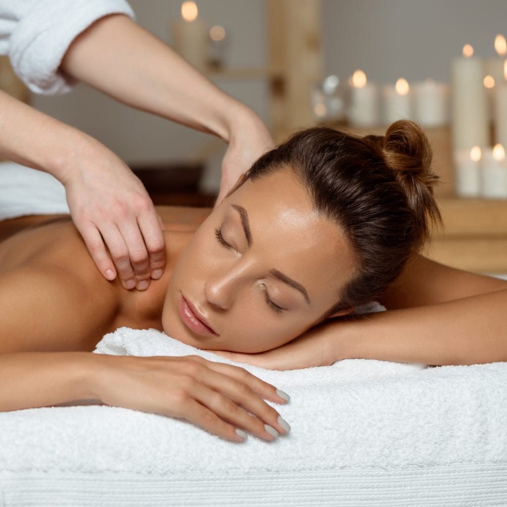 Image of Young woman having massage relaxing in spa salon.