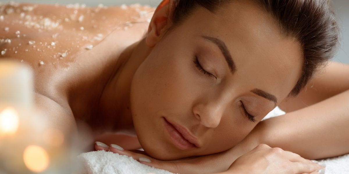 Image of a woman lying on her stomach with a body scrub on her back