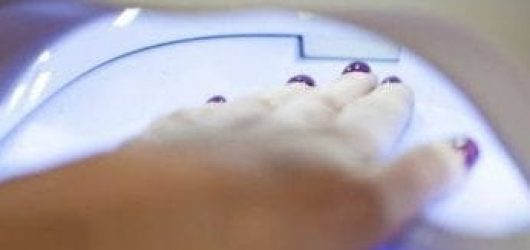 Woman filing nails using a nail file while doing her own nails. Woman filing nails using a nail file while doing her own nails.
