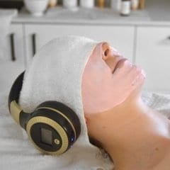 Young woman having a Ginger&Me Mindfulness Facial with headphones on