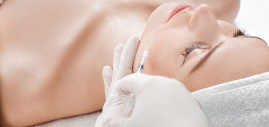 Cosmetic injectables A woman having a cosmetic injection in her face