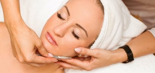 dermaplaning-image Image of a woman with her head wrapped in a towel, having a dermaplaning treatments